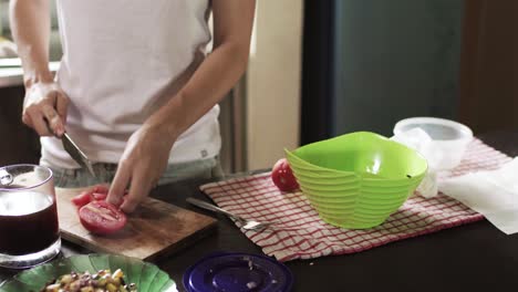 Girl-chopping-tomato-on-kitchen