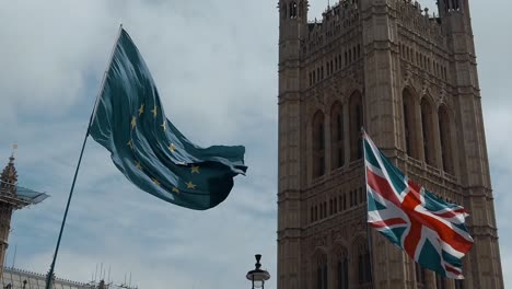 The-flags-of-the-European-Union-and-the-United-Kingdom-sway-in-the-wind-outside-the-Houses-of-Parliament