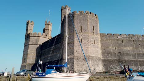 Caernarfon-Castle-Geschossen-Vom-Fluss-Seiont-Und-Zeigt-Die-Schlossfassade-Und-Den-Umliegenden-Tourismus-Und-Die-Boote