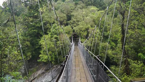 Swing-Bridge-over-blue-glacier-river-at-Hokitika-Gorge,-South-Island,-New-Zealand