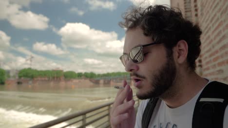 Slow-Motion-of-Guy-with-beard-and-Sun-Glasses-Smoking-Cigarette