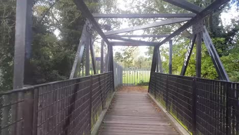 Walking-across-a-foot-bridge-over-the-River-Stour-in-Canterbury-Kent