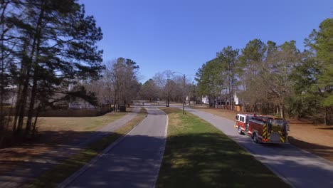 Aerial-of-a-firetruck-driving-on-a-road-on-its-way-to-an-emergency