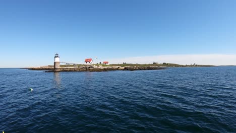 Flotando-Lentamente-Más-Allá-Del-Faro-De-La-Isla-Ram-Frente-A-La-Costa-Del-Puerto-De-Boothbay,-Maine