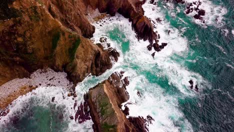 Waves-Break-on-Rocky-Cliffs-in-Shimmering-Turquoise-Ocean-in-Big-Sur
