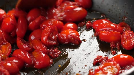 Stirring-sauteed-halved-cherry-tomatoes,-close-up-shot