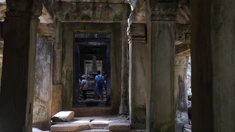 Angkor-Wat,-Cambodia-dolly-shot-of-group-of-tourists-sightseeing-ancient-ruins