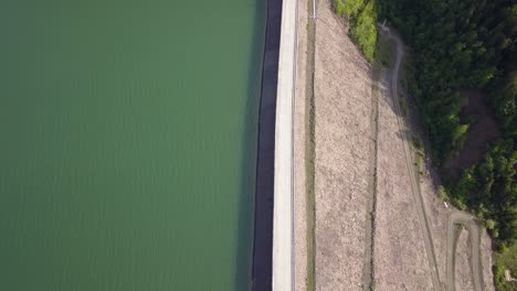 Aerial-Top-down-Show-of-road-splitting-water-and-landscape-,-symmetrical