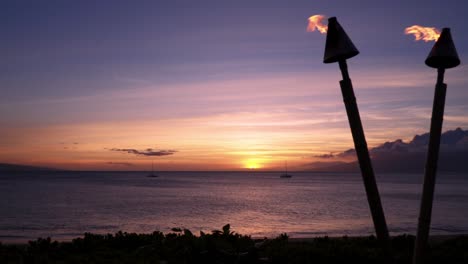 Blick-Auf-Den-Sonnenuntergang-An-Einem-Strand-In-Maui-Mit-Feuerfackeln