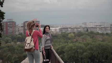Women-taking-photos-on-a-bridge-in-Belgrade,-Serbia