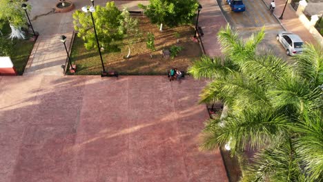 Toma-Aérea-De-Una-Pareja-En-El-Parque-San-Juan-Valladolid-Yucatan,-México