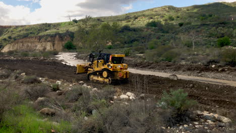 Bulldozer-Planieren-In-Einem-Flussbett,-Nachdem-Ein-Sturm-Die-Straße-Ausgewaschen-Hat-Winkel-2