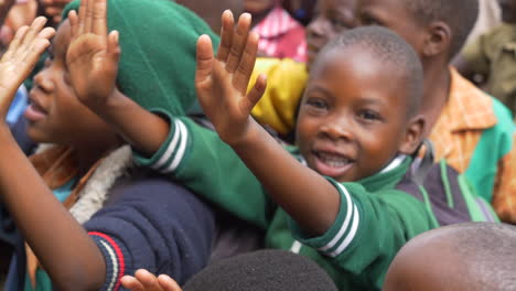 Young-African-Children-Receiving-High-Fives-from-White-Hands,-Close-Up-Slow-Motion