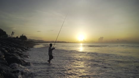 Ein-Traditioneller-Indonesischer-Fischer,-Der-Bei-Sonnenuntergang-Oder-Sonnenaufgang-An-Einer-Küste-Eines-Ozeans-Oder-Meeres-Fischt
