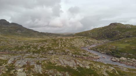 Rocky-green-Norway-Hardangervidda-valley-and-river,-aerial-side-truck-view