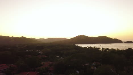 Filmische-Luftaufnahme-Eines-Tropischen-Dorfes-Am-Ufer-Eines-Ozeans
