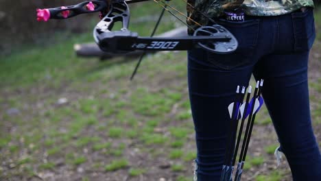 A-girl-pulling-an-arrow-out-of-her-boot-in-order-to-prepare-to-shoot-the-bow-and-arrow