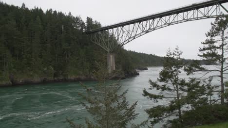 Fast-flowing-green-river-with-a-pan-towards-the-Deception-Pass-bridge