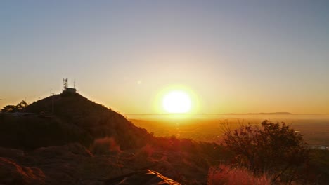 one-guy-sitting-and-taking-photo-of-sunset-on-top-of-mountain