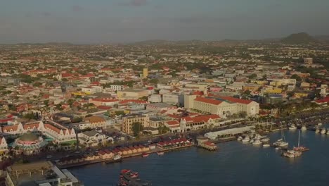 Luftzoom--Und-Schwenkansicht-Des-Schönen-Yachthafens-Und-Der-Belebten-Straßen-In-Der-Stadt-Oranjestad-Auf-Aruba