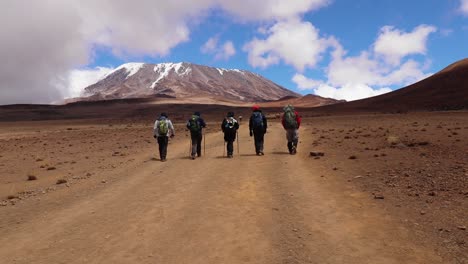 Static-shot-of-people-hiking,-in-a-group,-towards-the-summit-of-mount-Kilimanjaro,-on-a-sunny-day,-near-Horombo-hut,-in-Tanzania,-Africa
