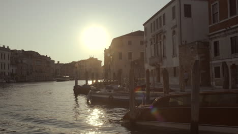 Boote-Am-Pier-Mit-Hintergrundbeleuchtung-Mit-Goldenem-Morgenlicht-Mit-Wasserreflexionen,-Venedig,-Canal-Grande,-Italien