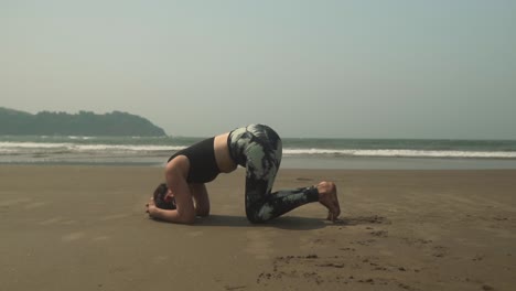 Yoga-headstand-position-asana-by-young-woman-on-beach-outdoors-exercise-Sirsasana