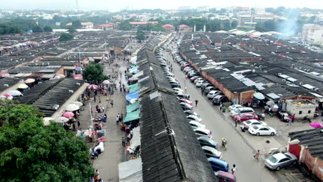 Storefront-stalls-and-people-shopping-at-Wusa-Market-in-Abuja,-Nigeria---aerial-flyover