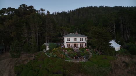 Orbiting-aerial-shot-of-a-private-mansion-on-the-California-coast-rented-out-as-a-wedding-reception-venue