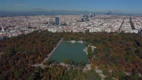Drohnenaufnahme-Des-Parque-De-El-Retiro-In-Madrid-–-Drohne-Steigt-Herab-Und-Blickt-Auf-Den-Großen-Teich-Und-Die-Stadt