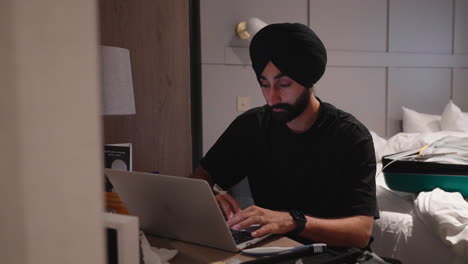 Indian-Man-In-Turban-Using-Laptop-Inside-His-Bedroom