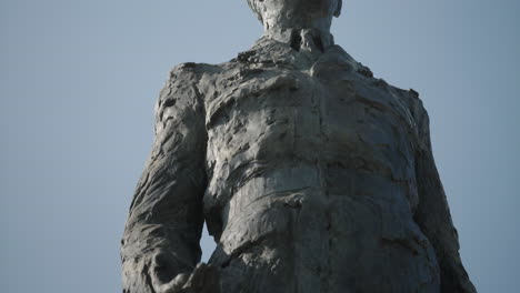 Slow-tilt-up-to-the-head-of-the-statue-general-of-Gaulle,-blue-sky,-outdoors