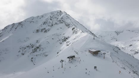 Schwenkende-Zeitlupen-Panorama-Drohnenaufnahme-Des-Obersten-Lifts-Und-Menschen,-Die-Im-Skigebiet-Bansko-Ski-Fahren