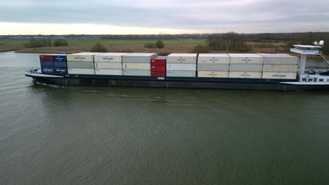 Luftaufnahme-Eines-Langsam-Fahrenden-Und-Schwer-Beladenen-Containerschiffs-Auf-Dem-Niederländischen-Kanal-„Oude-Maas“-In-Zwijndrecht,-Niederlande