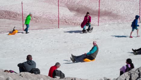 People-have-fun-tobogganing-on-the-Zugspitze-on-a-warm-summer-day