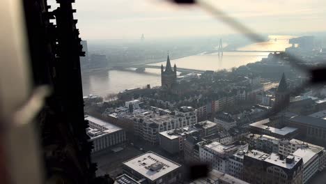 Dolly-forward-through-grid-of-Cologne-Cathedral-with-beautiful-view-over-City-and-River-during-sunset-time,Germany---Panorama-view