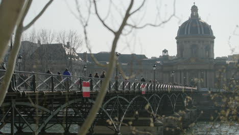 Reveal-historic-building-with-a-beautiful-dome-roof-and-ponts-des-arts-in-Paris
