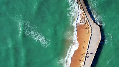 Top-down-aerial-view-of-the-street-in-the-atlantic-ocean-that-leads-to-the-fortress-of-San-Sebastian-in-Cadiz,-Spain