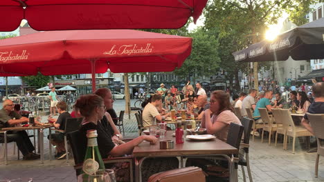Menschen-Essen-Im-Kölner-Restaurant-In-Der-Altstadt,-Während-Im-Hintergrund-Eine-Musikband-Spielt