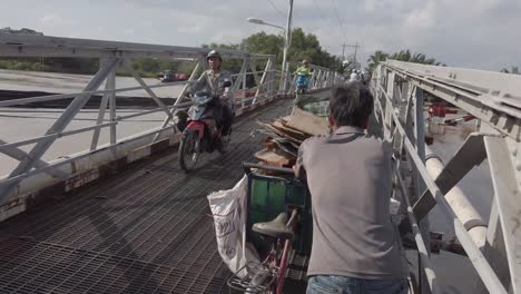 Ein-Mann-Rollt-Sein-Fahrrad-über-Eine-Schmale-Brücke-über-Einen-Kanal-Im-Bezirk-7-Von-Ho-Chi-Minh-Stadt