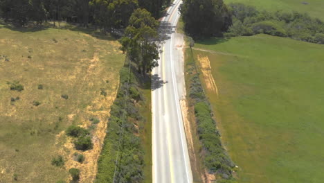 Aerial-view-of-endless-asphalt-road-leading-to-Big-Sur,-California
