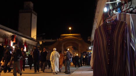 Street-view-of-local-men-and-women-shopping-in-Essaouira,-Morocco-at-night