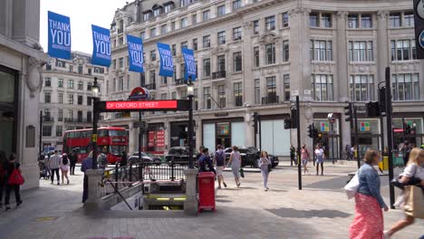 People-walk-past-the-Oxford-Street-tube-station-in-central-London,-UK