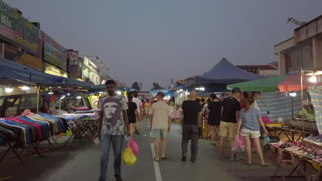 Eine-Frühe-Nachtaufnahme-Eines-Basars-In-Johor-Bahru,-Malaysia,-Mit-Menschen,-Die-Auf-Der-Straße-Hin-Und-Her-Gehen