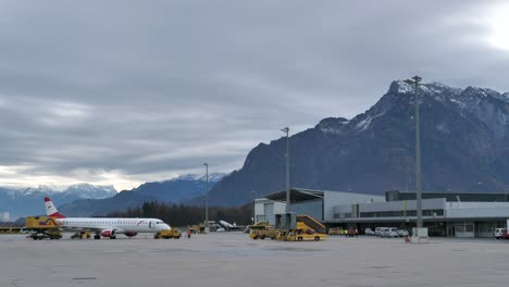 Salzburg-airport-with-plane-parked-on-apron,-cloudy-day