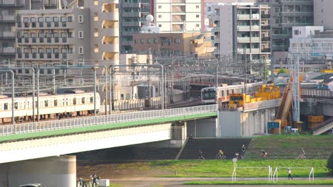 Trenes-Jr-Viajando-Y-Cruzando-El-Puente-En-Tamagawaon-Un-Día-Soleado-En-Tokio,-Japón