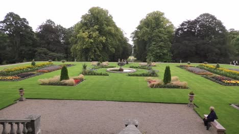 Young-family-enter-the-Haddo-formal-garden-with-a-lady-sitting-on-a-bench-watching