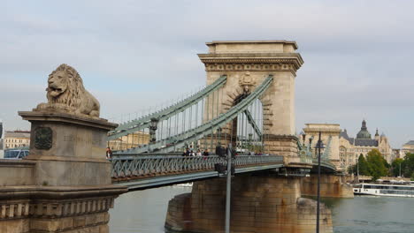 Tourist-people-walking-on-authentic-bridge-with-loin-over-river-Danube-in-Budapest-Hungary
