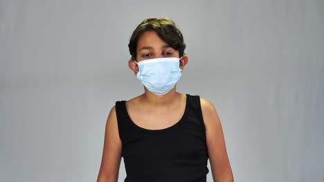 Portrait-of-middle-eastern-boy-wearing-medical-mask,-isolated-on-grey-background