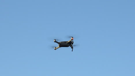 Dron-Flotando-En-El-Aire-Mientras-Otro-Dron-Vuela-Cerca-A-Alta-Velocidad